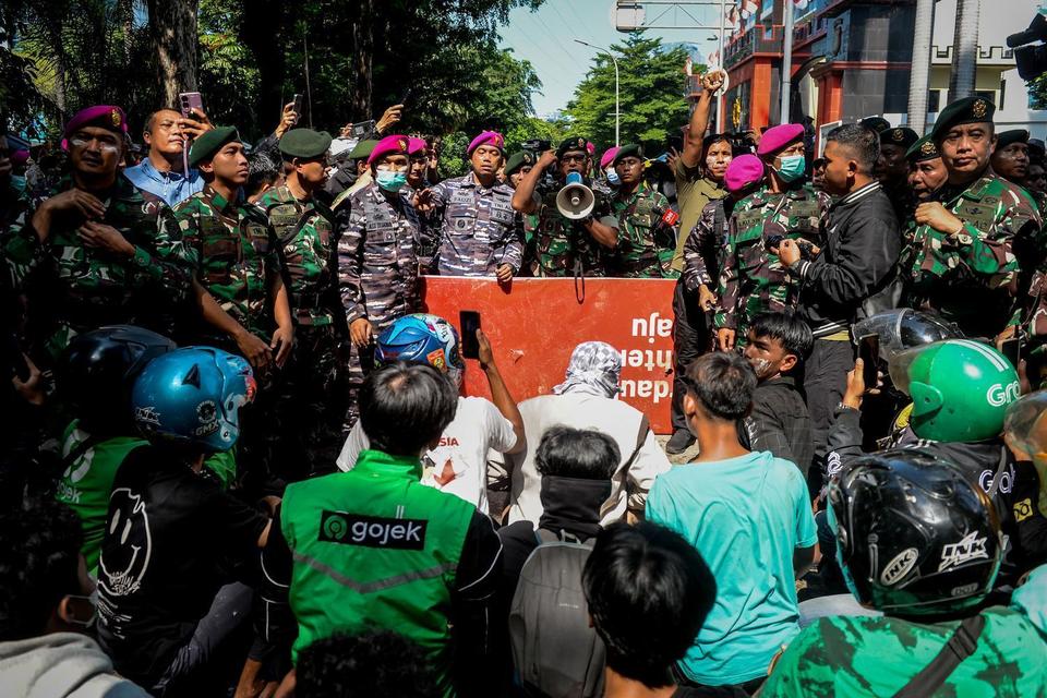 Personel TNI Angkatan Laut berdialog dengan pengunjuk rasa saat aksi menuntut pengusutan kasus penabrakan pengemudi ojek online oleh mobil rantis Brimob di Kwitang, Jakarta, Jumat (29/8/2025).