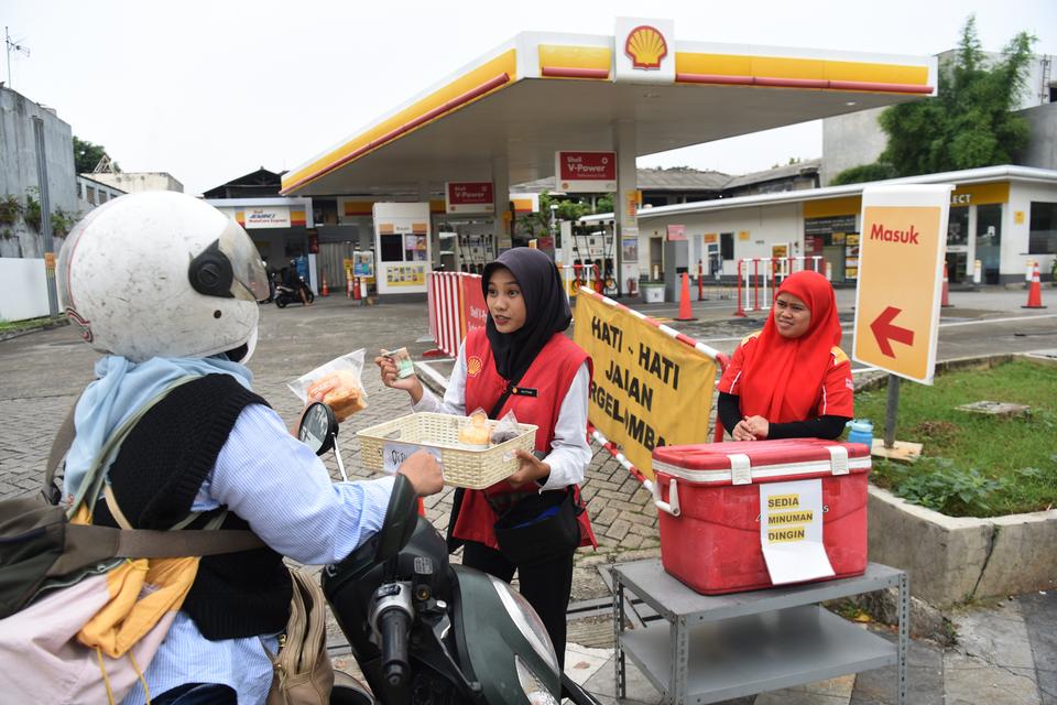 Pengendara motor membeli makanan yang dijual petugas SPBU di depan SPBU Shell, Jalan Margonda Raya, Depok, Jawa Barat, Kamis (18/9/2025). Menteri Energi dan Sumber Daya Mineral (ESDM) Bahlil Lahadalia memastikan pemerintah terus memantau situasi di lapang