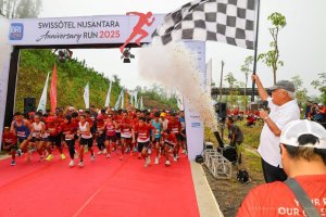Kepala Otorita IKN, Basuki Hadimuljono (kanan), mengibarkan bendera start sebagai tanda dimulainya Swissôtel Nusantara Anniversary Run 2025 di Kawasan