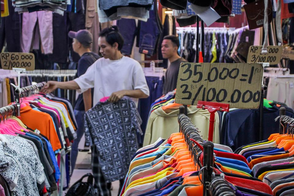 Calon pembeli melihat pakaian bekas yang dijual di Pasar Senen, Jakarta, Jumat (24/10/2025). Menteri Keuangan Purbaya Yudhi Sadewa mengatakan pihaknya akan melarang praktik impor bal pakaian bekas ilegal dalam karung atau balpres karena dapat merugikan ne