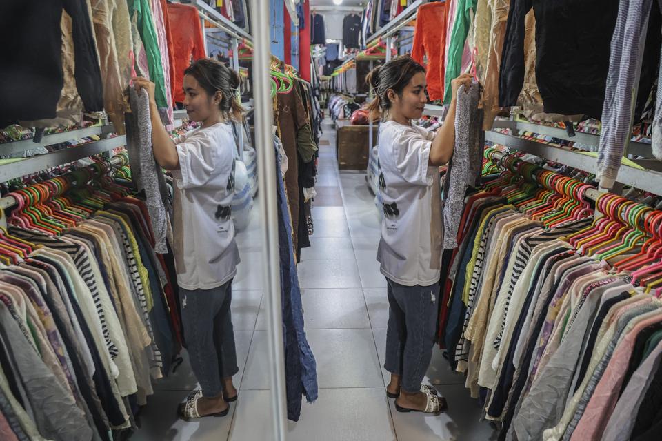 Seorang pengunjung memilih pakaian impor bekas di Pasar Higienis Ternate, Maluku Utara, Rabu (5/11/2025). Para pedagang thrifting setempat mengusulkan kepada pemerintah untuk menyusun peta jalan yang jelas dan terukur setelah adanya pelarangan impor pakai