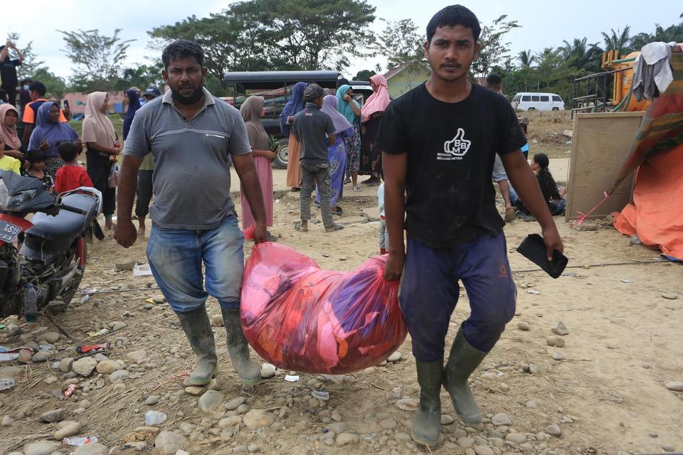 Sejumlah warga korban banjir mengangkut bantuan yang diterima dari dermawan di tempat pengungsian Desa Geudumbak, Kecamatan Langkahan, Aceh Utara, Aceh, Sabtu (6/12/2025). Berbagai bantuan dari mahasiswa dan para dermawan mulai berdatangan seperti pakaian