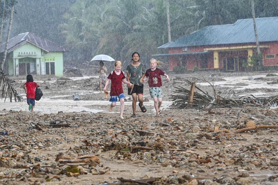 Warga korban bencana banjir dan tanah longsor berlarian untuk mengambil bantuan di Kelurahan Huta Nabolon, Kecamatan Tukka,Tapanuli Tengah, Sumatera Utara, Minggu (7/12/2025). Warga di empat desa wilayah tersebut hanya bisa mengambil bantuan di saat ali