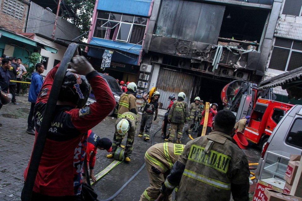 Petugas pemadam kebakaran merapihkan selang air usai memadamkan api di perkantoran Terra Drone di jalan Letjen Soeprapto, Cempaka Baru, Kemayoran, Jakarta, Selasa (9/12/2025).