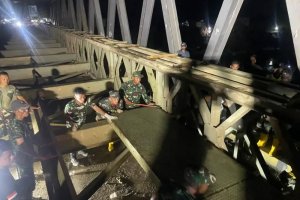 Personel TNI bersama warga menyelesaikan penyambungan Jembatan Teupin Reudeup di Aceh Utara.