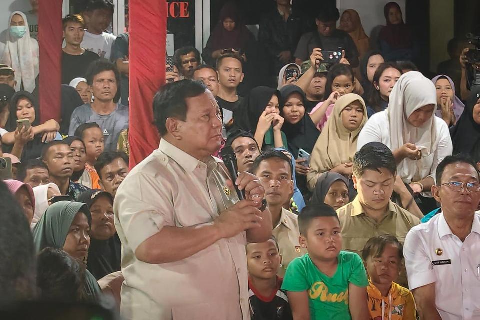 Presiden Prabowo Subianto (tengah) didampingi Bupati Tapanuli Selatan Gus Irawan Pasaribu (kanan) menyampaikan pesan kepada para pengungsi bencana banjir bandang menjelang pergantian tahun di Posko Pengungsian Batu Hula, Kabupaten Tapanuli Selatan, Sumate