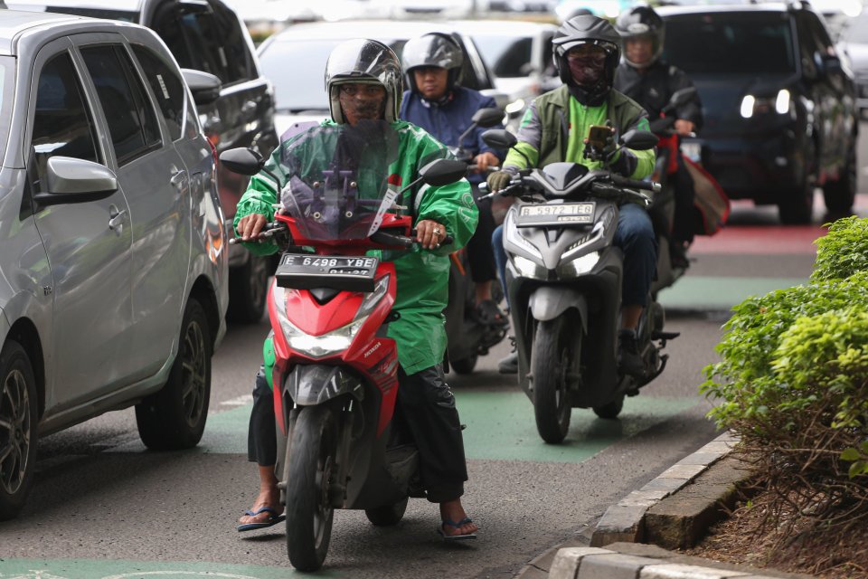 Pengemudi ojek online (ojol) melintas di Jalan Gatot Subroto, Jakarta, Kamis (5/3/2026). Pemerintah menetapkan besaran Bonus Hari Raya atau BHR untuk mitra pengemudi taksi online dan ojol yakni 25% dari rata-rata pendapatan bersih selama 12 bulan terakhir