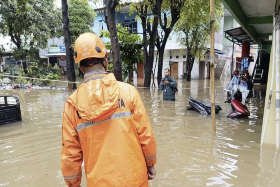 Seorang petugas BPBD DKI Jakarta saat memantau kondisi banjir di Jakarta, Minggu (8/3/2026). \