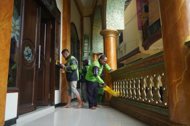 Mitra driver Gojek melakukan bersih-bersih di sebuah masjid sebagai wujud kebersamaan di bulan Ramadan.