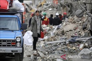  Seorang wanita berjalan di antara reruntuhan dekat Lapangan Risalat setelah serangan Israel dan AS menyebabkan kerusakan parah di Teheran timur, Iran