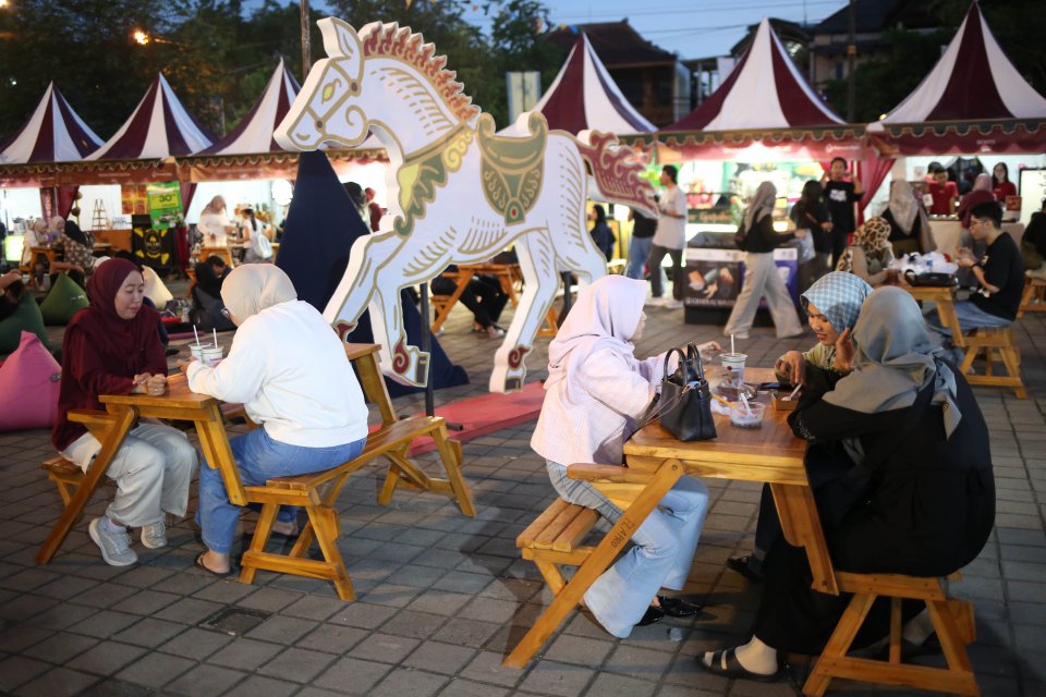Pengunjung menyantap makanan yang dibeli di festival kuliner MakaN-MakaN di Pamedan Pura Mangkunegaran, Solo, Jawa Tengah, Jumat (1/5/2026). Festival tersebut digelar dalam rangka memeriahkan adeging atau hari jadi Pura Mangkunegaran ke-269. 