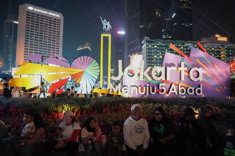 Warga menghadiri malam puncak HUT ke-499 Kota Jakarta di kawasan Bundaran HI, Sabtu (27/6/2026). Acara tersebut dimeriahkan berbagai pertunjukkan mulai dari video mapping, instalasi seni, atraksi pencahayaan hingga panggung hiburan yang menampilkan konser