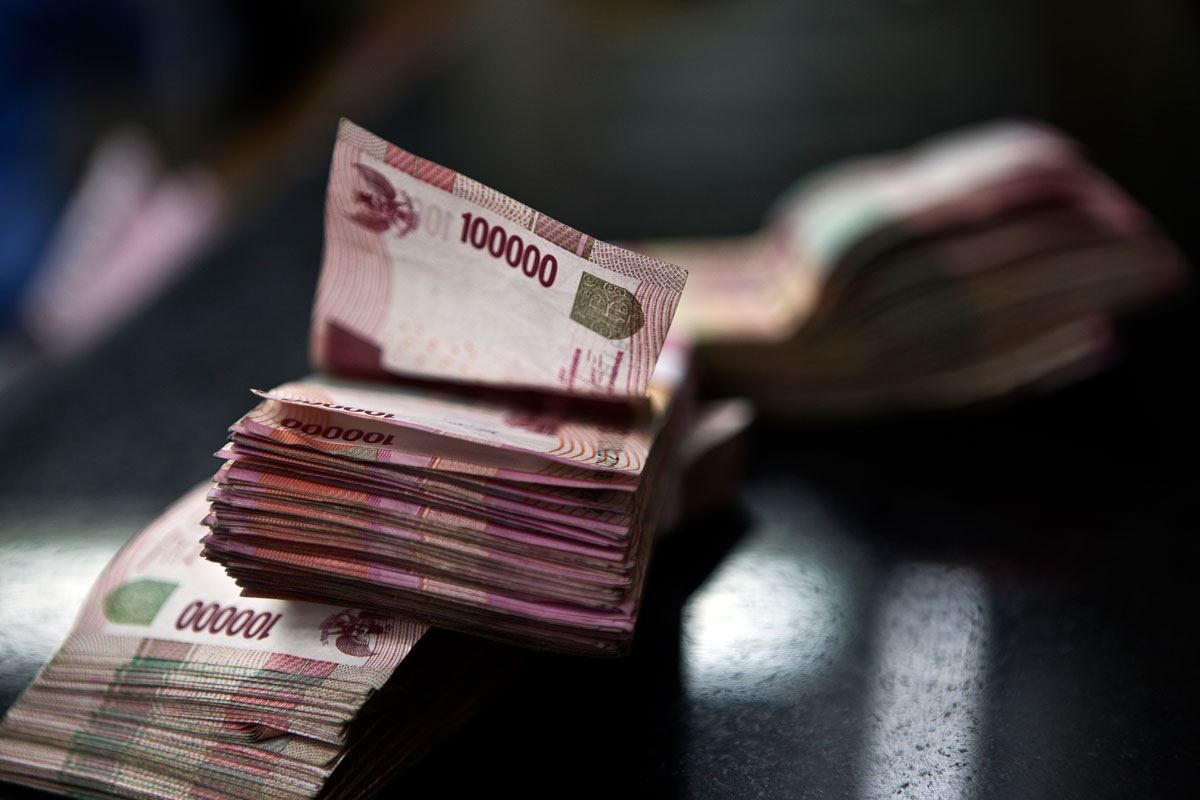 Petugas penukaran mata uang merapihkan uang yang hendak ditukar dengan mata uang asing di salah satu tempat penukaran uang di Jakarta